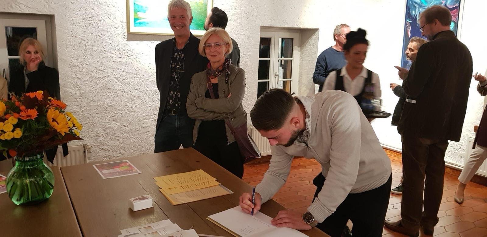Publique qui signe le livre d'or de Dominique Binet pendant son exposition à Steinsel.